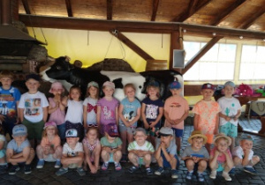 Grupa dzieci 4-letnich w stodole.